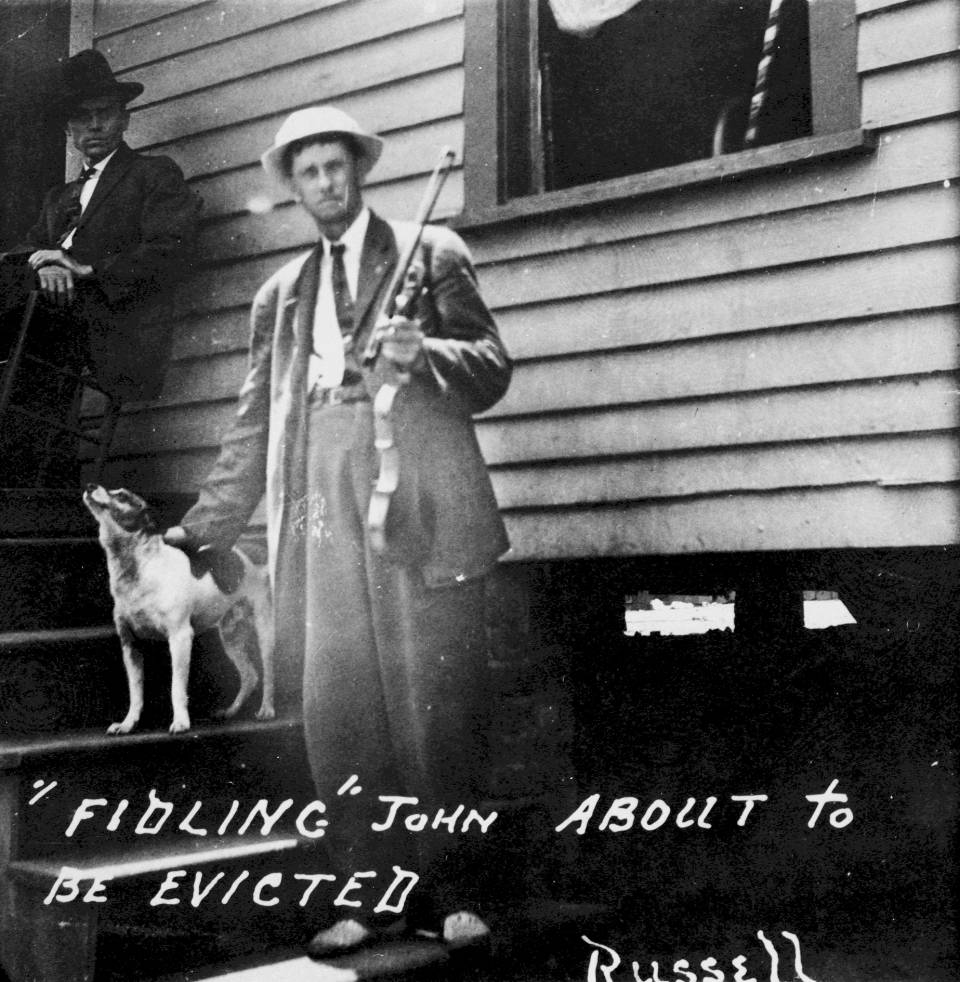Fiddlin' John Carson stands outside his home in Cabbagetown in 1914 during the Fulton Bag & Cotton Mill Strike. Courtesy Southern Labor Archives, Georgia State University Library Special Collections and Archives.
