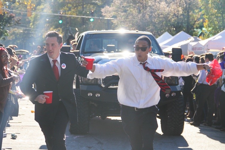 President Barack Obama and Presidential Candidate Mitt Romney impersonators run to catch up with the rest of the party.