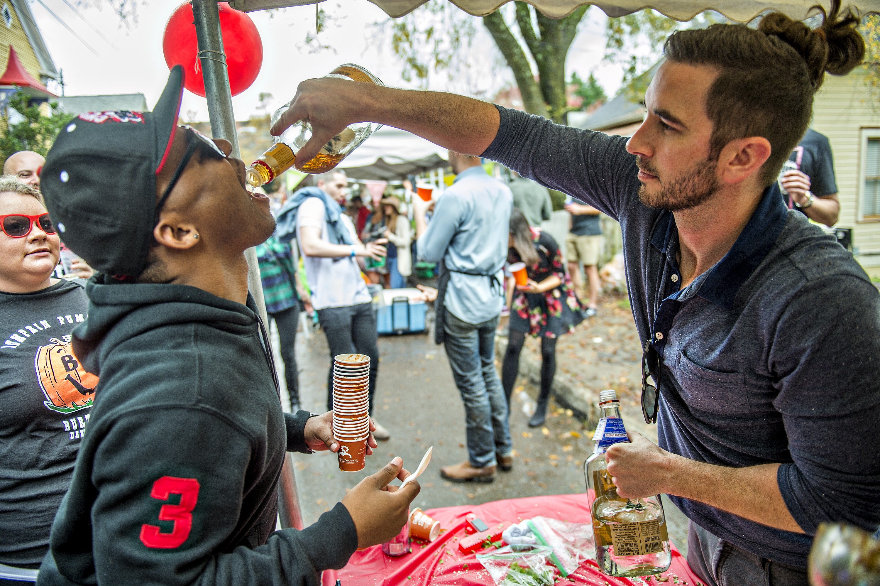 Photo: Jonathan Phillips. Derek Little (right) gives Russell Owen a shot of tequila at the Chomp & Stomp Festival.