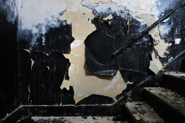 At the top of the staircase, paint peels off a wall and appears to take on many different forms. Photo by Joeff Davis.